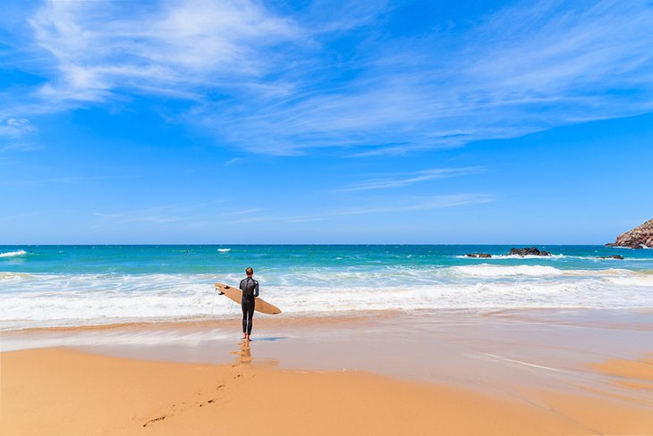 Surfista revisando las olas en Praia do Amado